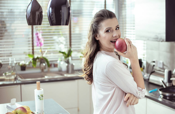 Portrait of a pretty lady biting an apple - Foto, afbeelding