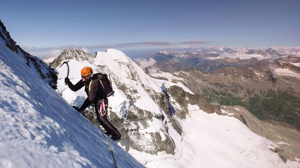 alpiniste mâle sur un haut glacier alpin avec une vue imprenable sur le fantastique paysage de montagne derrière lui
 - Photo, image