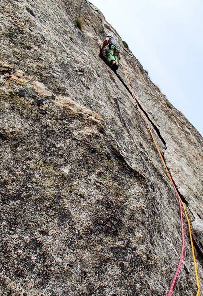 arrampicatore maschile su una via di arrampicata dura e ripida nelle pareti granitiche della Val Bregaglia in Svizzera
 - Foto, immagini