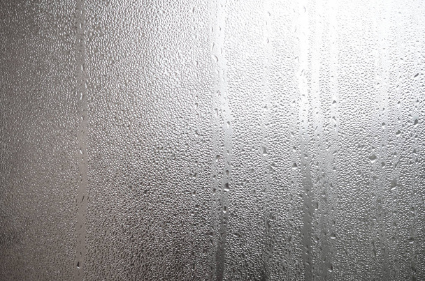 Una foto de la superficie de cristal de la ventana, cubierta con una multitud de gotas de varios tamaños. Textura de fondo de una densa capa de condensado sobre vidrio
 - Foto, imagen