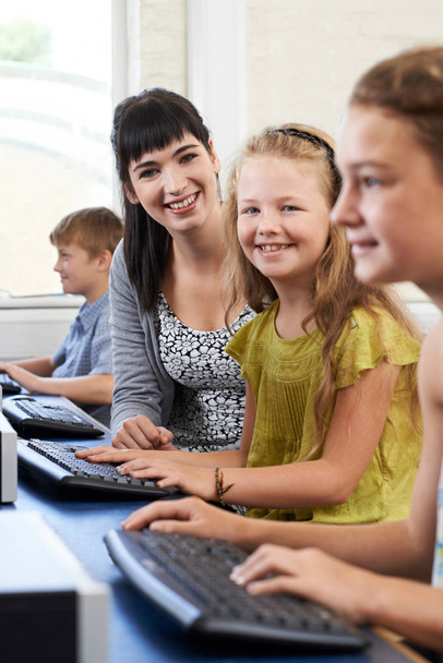 Portrait Of Female Elementary Pupil In Computer Class With Teach - Foto, afbeelding