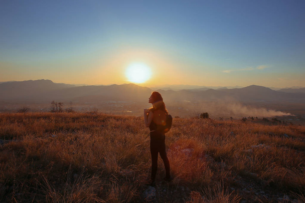 La montagne du coucher du soleil. Touriste femme heureuse libre bras tendus esprit
 - Photo, image