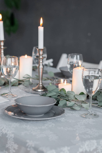 Wedding or festive table setting. Plates, wine glasses, candles and cutlery - Фото, изображение