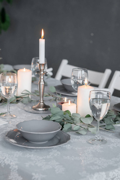 Wedding or festive table setting. Plates, wine glasses, candles and cutlery - Fotografie, Obrázek