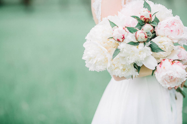 Ομορφιά γαμήλια ανθοδέσμη παιωνία ροζ και λευκά λουλούδια στα χέρια της νύφης. - Φωτογραφία, εικόνα