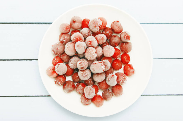 Ripe fresh cherry, frozen in freezer. Berries on wooden table. Top view - Foto, imagen