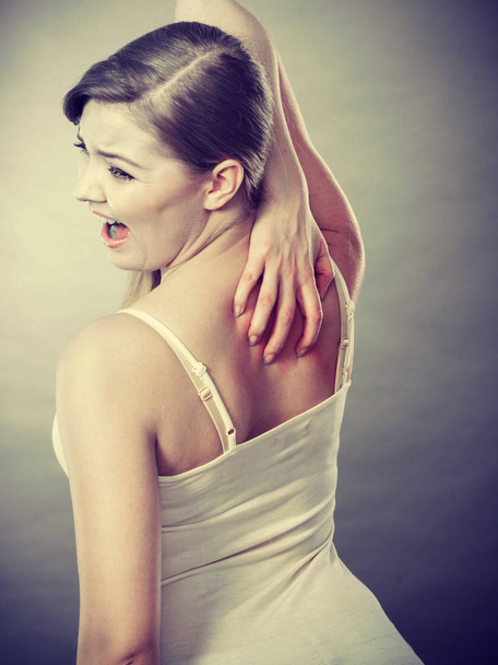 woman scratching her itchy back with allergy rash - Fotó, kép