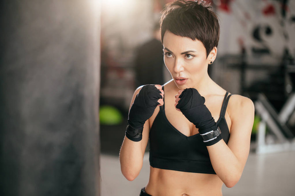 closeup shot of muscular woman learning to beat with fists indoors - Foto, Imagem