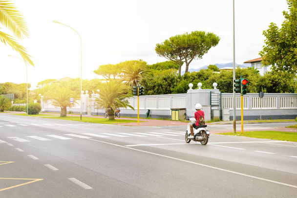 Vista de la luz del día al motociclista esperando en el semáforo rojo
 - Foto, imagen
