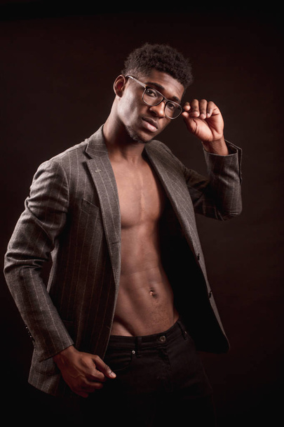 slim sexy Afro american guy with glasses wearing stylish coat and black trousers - Fotografie, Obrázek