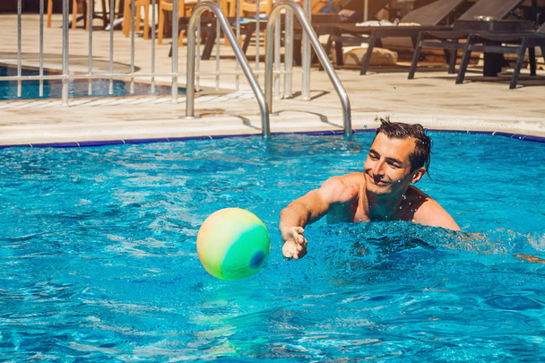Mladý muž hraje vodní pólo v bazénu. Vodní sporty. Koncept zdravého životního stylu. - Fotografie, Obrázek