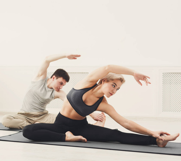 Fitness-Paar dehnt sich vor weißem Hintergrund - Foto, Bild