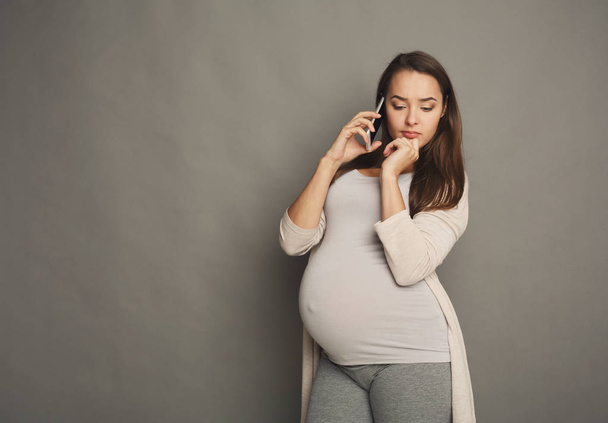 Inquiète femme enceinte parler sur l'espace de copie de téléphone
 - Photo, image