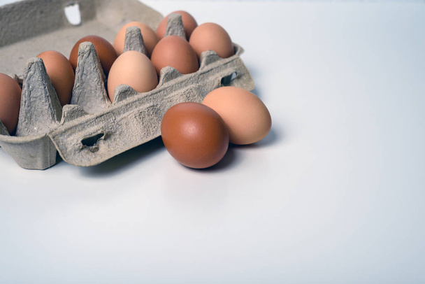 Minimalistinen asetelma maalaismaisten munien kanssa paperisäiliössä
 - Valokuva, kuva