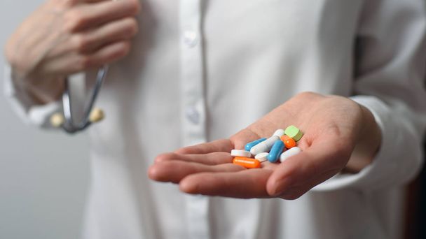 Värikkäitä tabletteja kämmenellä nainen lääkäri valkoinen paita
 - Valokuva, kuva