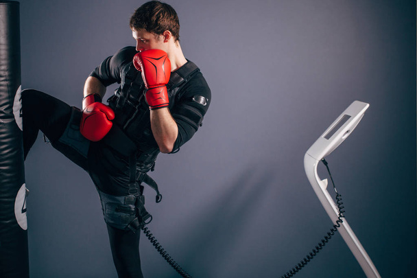 man training knee kick. A kickboxer wearing suit of electric stimulation - Foto, immagini