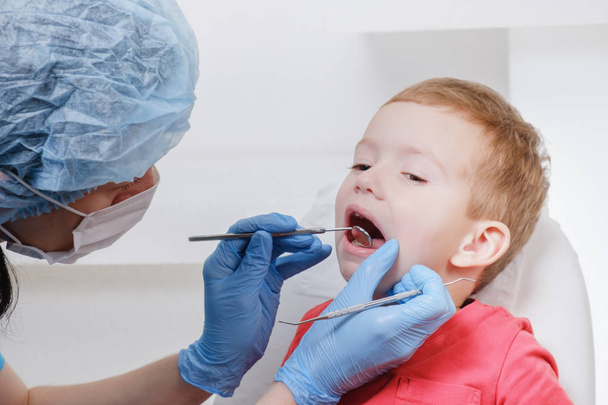 Dentist examination of child patient teeth using a mirror of instrument Caries, tooth damage, illness. - Photo, image
