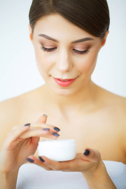 Una mujer hermosa usando un producto para el cuidado de la piel, crema hidratante o loti
 - Foto, Imagen