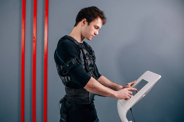 athlete regulating intensity of ems electro muscular stimulation machine - Photo, Image