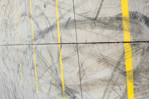 Gumiabroncs nyomok betonon, mint absztrakt grunge textúra - Fotó, kép