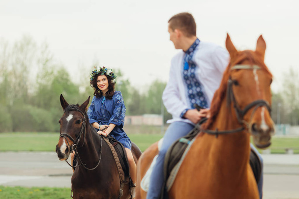 前にも馬に乗る彼のガール フレンドに彼の肩越しに見ている乗馬の男 - 写真・画像