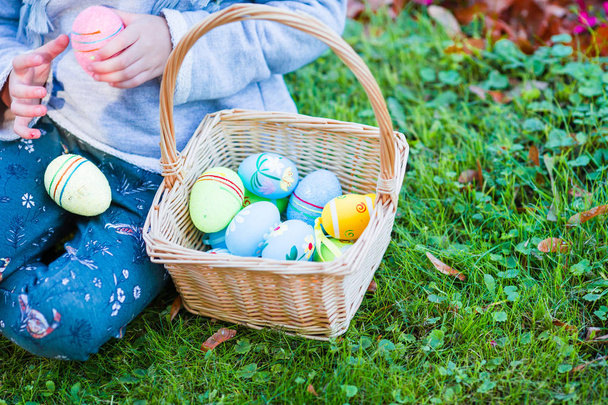 Lähikuva kori täynnä värikkäitä pääsiäismunia lasten käsissä
 - Valokuva, kuva