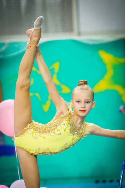 Little gymnast participates in competitions in rhythmic gymnastics - Zdjęcie, obraz