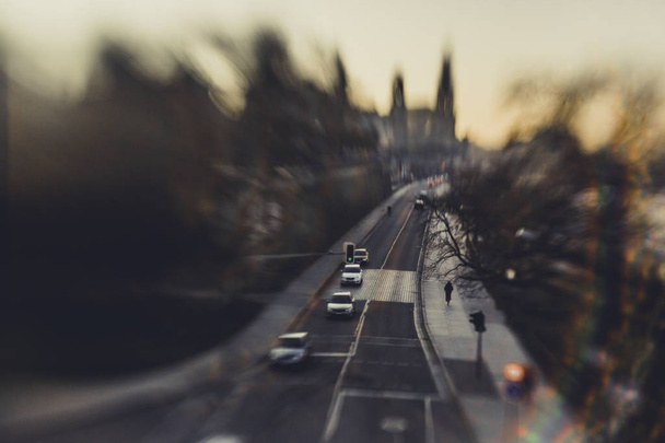 θολή φωτογραφία της παλιάς πόλης με το δρόμο και τα αυτοκίνητα κατά το ηλιοβασίλεμα - Φωτογραφία, εικόνα