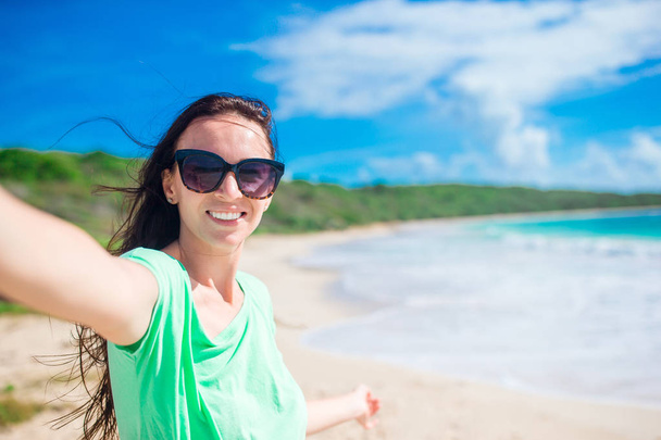 Young woman taking selfie portrait background turquiose ocean - Foto, Imagen