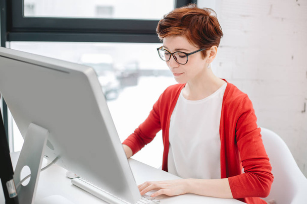 businesswoman typing on keyboard in bright office - 写真・画像