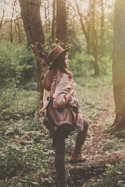 pełnej długości traveler czeskiego dziewczyna w kapeluszu i poncho z plecak spacer w lesie jesienią, widok z tyłu - Zdjęcie, obraz