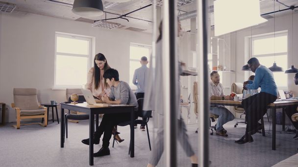 Multi-etnisch team werken in moderne trendy kantoor. Gelukkig jonge creatieve millennials glimlachend werken in licht coworking 4k. - Video
