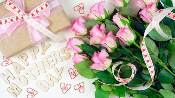 Dzień matki napowietrznych z daru i różowe róże na tle biały stół z drewna - Zdjęcie, obraz