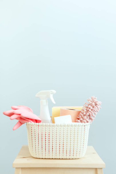 set of cleaning products in a white plastic basket, blue wall background - Foto, Bild