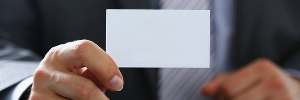 Мужская рука в костюме дает пустую визитную карточку
 - Фото, изображение