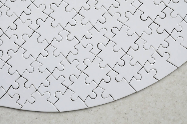 Bílé puzzle v úplné podobě leží na ošetřených kamenného povrchu. Obraz s texturou s kopií prostor - Fotografie, Obrázek