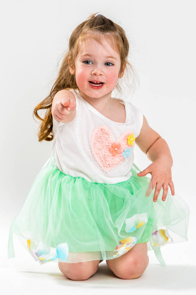 Porträt eines kleinen fröhlichen Mädchens auf hellem Hintergrund - Foto, Bild