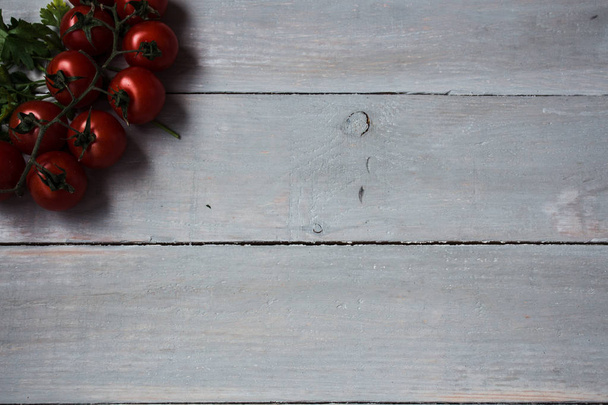 tomatoes with greens on wooden background - Photo, image