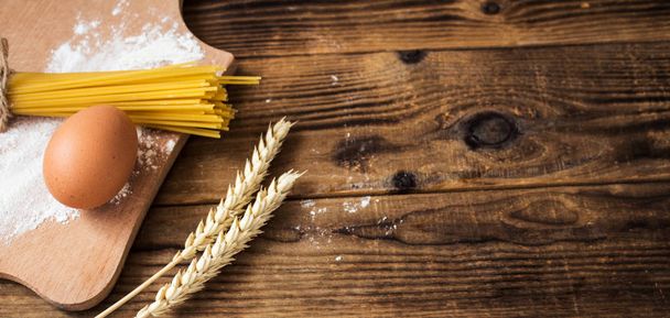 spaghetti and flour on wooden background - Valokuva, kuva