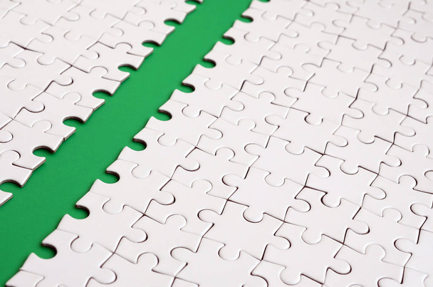 Le chemin vert est posé sur la plate-forme d'un puzzle plié blanc. Image de texture avec espace de copie pour le texte
 - Photo, image