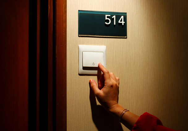 women hand pressing hotel door bell button - Photo, Image