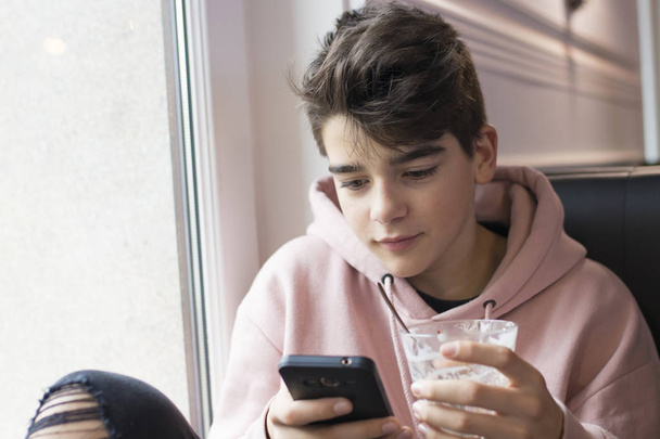 bambino adolescente o preadolescente con telefono cellulare e tazza
 - Foto, immagini