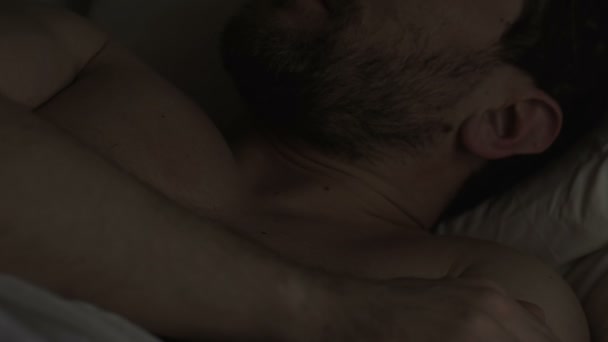 Erschöpfter, schläfriger Mann, der frühmorgens den Wecker umstellt, Faulheit - Filmmaterial, Video
