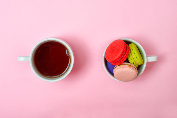 Renkli tatlı macaroons ve bir fincan çay. Lezzetli kahvaltı. Üstten Görünüm. - Fotoğraf, Görsel
