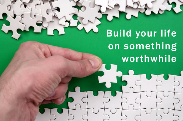 Build your life on something worthwhile. The hand folds a white  - Photo, Image