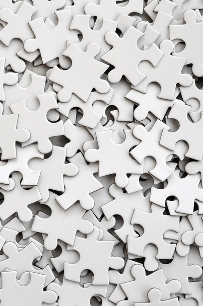Close-up de uma pilha de elementos incompletos de um quebra-cabeça branco. Um grande número de peças retangulares de um grande mosaico branco
 - Foto, Imagem