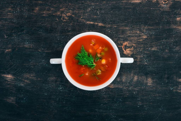 Zupa pomidorowa z chili i warzywa. Zdrowe jedzenie. Na czarnym tle drewnianych. Widok z góry. Miejsce dla tekstu. - Zdjęcie, obraz