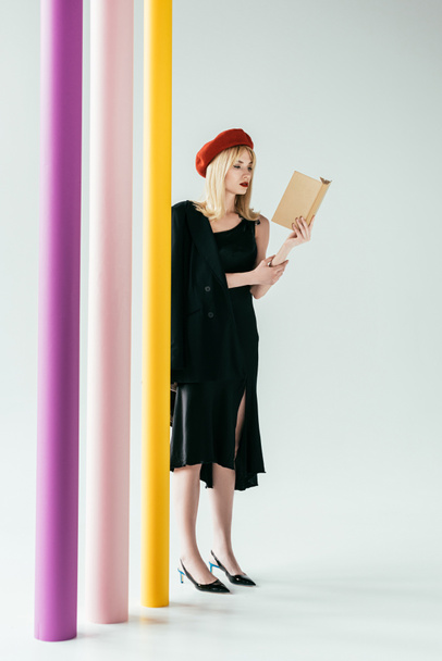 Elegáns fekete ruha olvasás könyv színes oszlop csinos nő - Fotó, kép