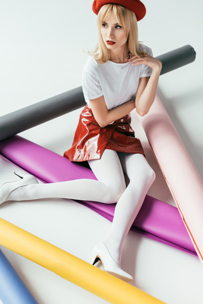 Elegante ragazza bionda in posa tra rotoli di carta colorati
 - Foto, immagini