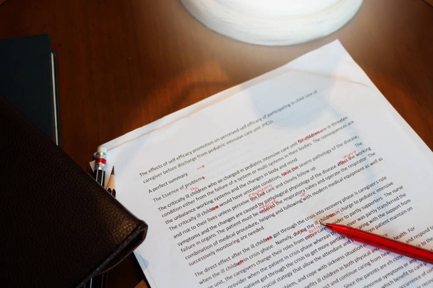 proofreading paper on wooden desk - Photo, Image